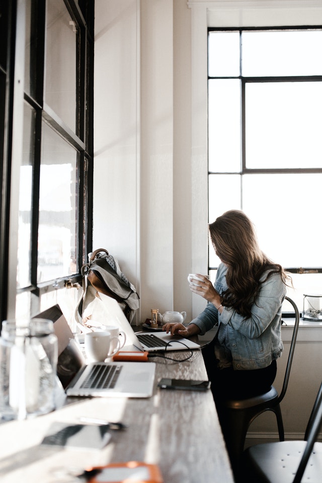 gambar seorang wanita sedang bekerja dengan laptop